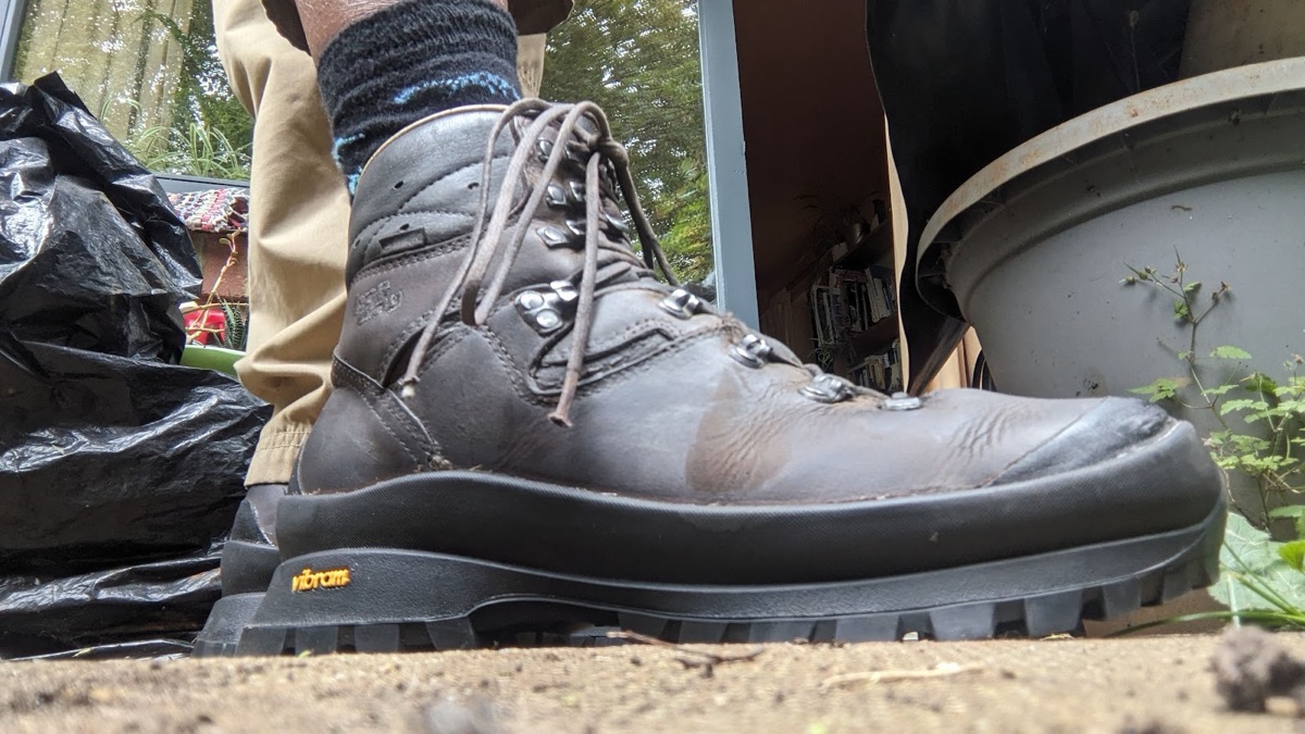 A brown leather hiking boot with a genuine Vibram sole, the orange Vibram logo stamped on the heel.